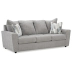 Szara tapicerowana sofa z rozchylonymi podłokietnikami